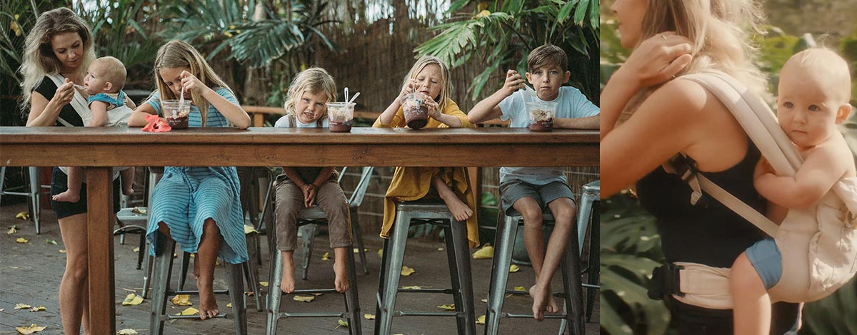 Family enjoying acai bowls and mom carrying baby in baby carrier on her back